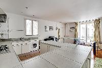 large kitchen with kitchen counter, washer and dryer combo in a 1-bedroom Paris luxury apartment