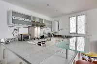 large kitchen with kitchen counter, washer and dryer combo in a 1-bedroom Paris luxury apartment