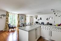 large kitchen with kitchen counter, washer and dryer combo in a 1-bedroom Paris luxury apartment