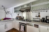 large kitchen with kitchen counter, washer and dryer combo in a 1-bedroom Paris luxury apartment