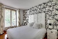 cozy bedroom with a king-size bed and large, custom-fitted wardrobes in a 1-bedroom Paris luxury apa