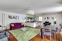 large living area, dining area, and kitchen in a 1-bedroom Paris luxury apartment