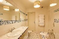 en-suite bathroom with a bathtub and a handheld shower head in a 1-bedroom Paris luxury apartment