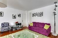 large living room sofa bed and several armchairs in a 1-bedroom Paris luxury apartment
