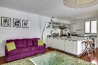 large living room sofa bed and kitchen in a 1-bedroom Paris luxury apartment