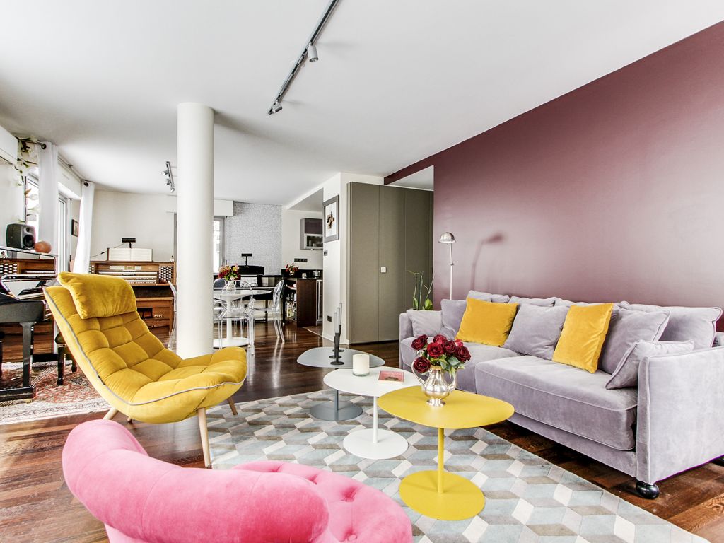 living room in yellow and rose hues with a double sized sofa-bed and three antique pianos in a 1-bed