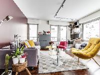 living room in yellow and rose hues with a double sized sofa-bed and three antique pianos in a 1-bed