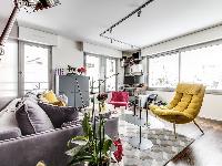 living room in yellow and rose hues with a double sized sofa-bed and three antique pianos in a 1-bed