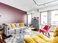 living room in yellow and rose hues with a double sized sofa-bed and three antique pianos in a 1-bed