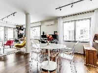 stylish dining area with a table and designer acrylic clear chairs  in a 1-bedroom Paris luxury apar