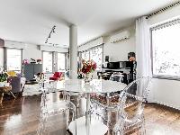 stylish dining area with a table and designer acrylic clear chairs  in a 1-bedroom Paris luxury apar