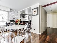 stylish dining area with a table and designer acrylic clear chairs  in a 1-bedroom Paris luxury apar