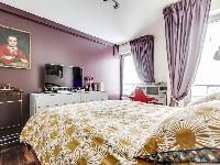 cozy bedroom with a queen-size bed, plenty of storage space and a TV in a 1-bedroom Paris luxury apa