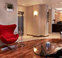 elegant red chair and glossy wooden floor at the lobby of Hotel Verlain in Paris