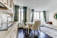 elegant open plan living and dining area with white dining table and chairs, fully equipped kitchen,