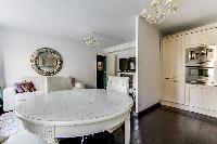 elegant open plan living and dining area with white dining table and chairs, fully equipped kitchen,