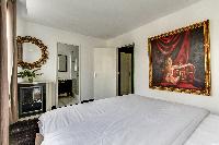 elegant bedroom with a king-size bed, large framed artwork and an en suite gorgeous bathroom in Pari