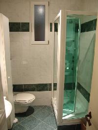 sleek bathroom with a nice shower stall with water massage selections and toilet in Paris luxury apa