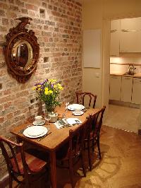 stylish brick-walled dining area with wooden table and chairs for 4 and well-equipped kitchen in Par