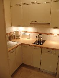 fully functional kitchen equipped with a fridge, compact oven, vitro ceramic stove, microwave, dishw