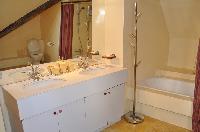 large bathroom with two sinks, full-sized mirror, washing machine and a dryer, a toilet, and a large