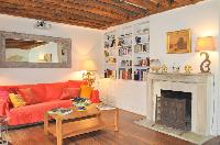 a warm and bright living room with original exposed beamed ceilings, parquet floors, large lovely so