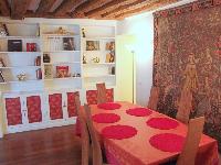 dining area for 6 with styish carpet, exposed beams and shelves in a 2-bedroom Triplex Paris apartme