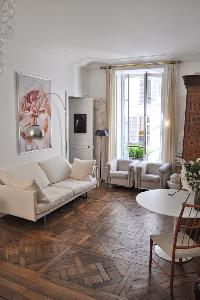 white-themed living area with French glass windows open out to the quiet and beautiful courtyard gar