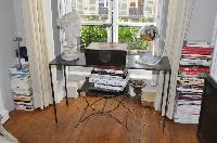 glass study desk, bust, and tower of books in Paris luxury apartment