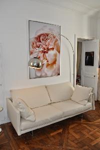 white sofa, arc floorlamp,and framed artwork in Paris luxury apartment