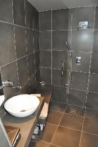 sleek gray-tiled shower area in Paris luxury apartment