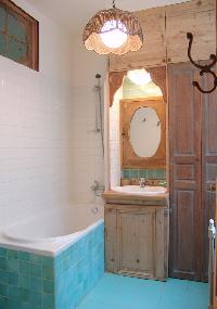 turquoise-tiled bath with ceiling lamp in Paris luxury apartment