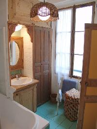 turquoise-tiled bath with ceiling lamp in Paris luxury apartment