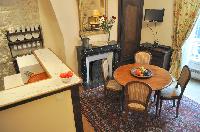 classy kitchen and dining area with wooden round table for 4 in Paris luxury apartment