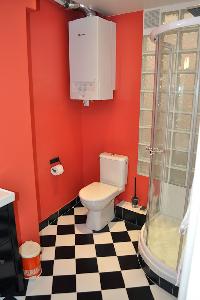 sleek bathroom with black-and-white tiles and red wall in Paris luxury apartment