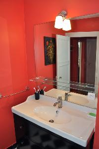 sleek bathroom with black-and-white tiles and red wall in Paris luxury apartment