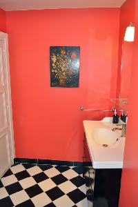 sleek bathroom with black-and-white tiles and red wall in Paris luxury apartment