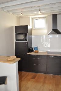 well-equipped kitchen with breakfast bar and stools in Paris luxury apartment