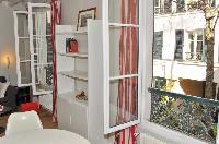 two large windows that open onto the view of a quiet courtyard in Paris luxury apartment