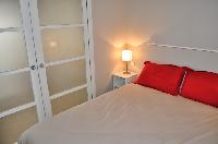 neatly stocked bedroom separated by a sliding door from the living room in Paris luxury apartment