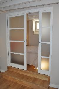 white sliding door opens to the bedroom in Paris luxury apartment