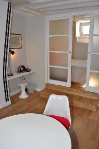 dining area with mini study area, sliding door access to the bedroom in Paris luxury apartment