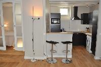 well-equipped kitchen with breakfast bar and stools in Paris luxury apartment