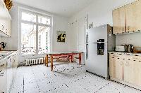 well-equipped kitchen with dining table and chairs in a 4-bedroom Paris luxury apartment