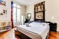 second bedroom features a king-sized style bed and ensuite in a 4-bedroom Paris luxury apartment