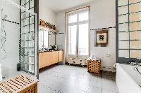 light-filled bathroom, equipped with both a bathtub and shower in a 4-bedroom Paris luxury apartment