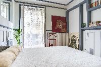 master bedroom with a queen size bed and access to the small balcony via a large floor to ceiling wi