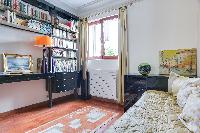 neatly-stocked, bright, and comfortable bedroom in a 2-bedroom Paris luxury apartment