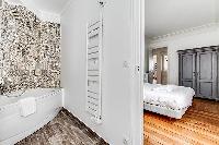 master bedroom and en suite bathroom with artistic walls  in a 3-bedroom Paris luxury apartment