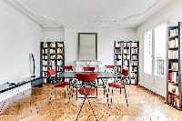 spacious dining area with 4 seats and book shelves in a 3-bedroom Paris luxury apartment